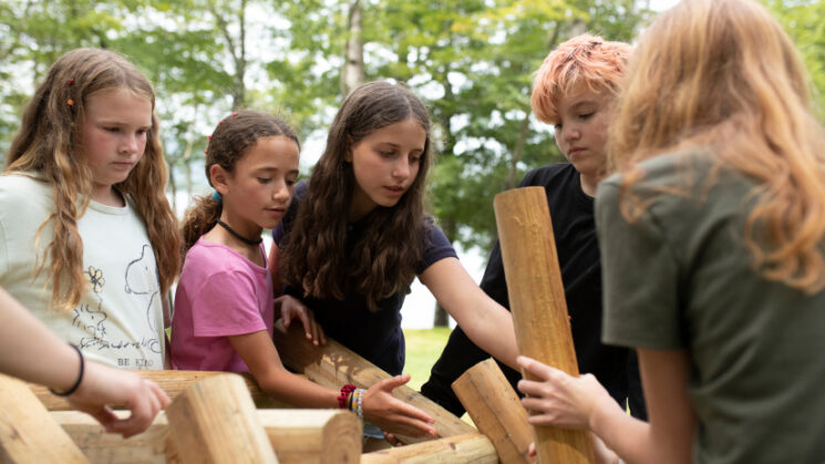 Girls building with wood.